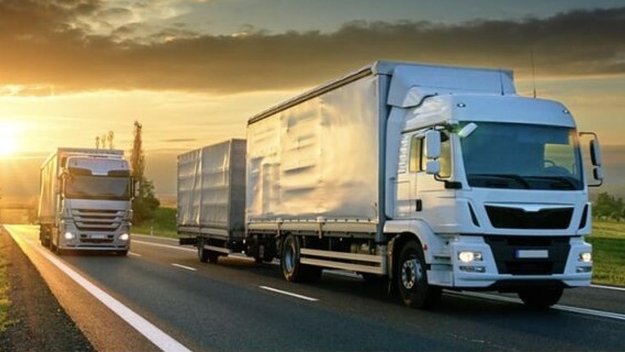 Trucks on road at sunset